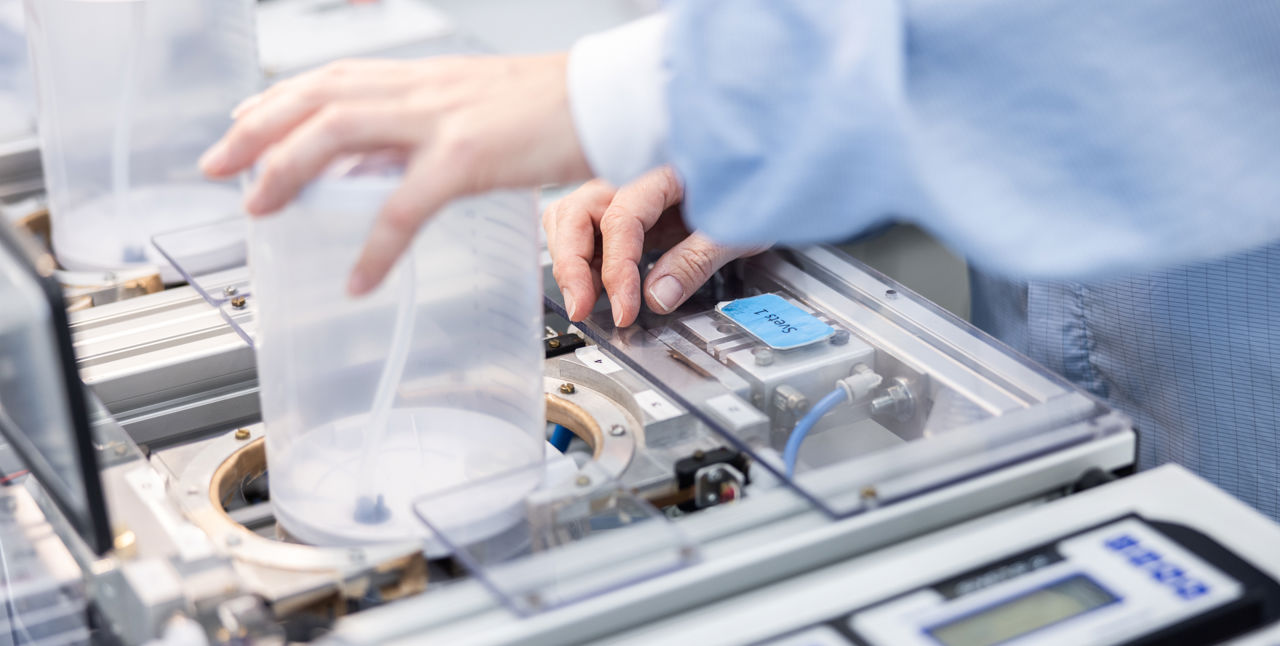 Hands welding a plastic lid.