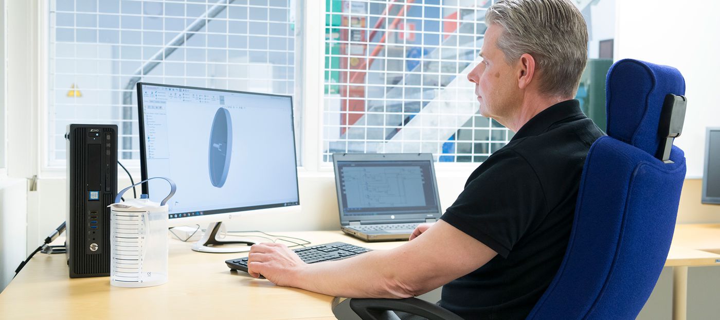 Man sitting in front of a computer, working with CAD.